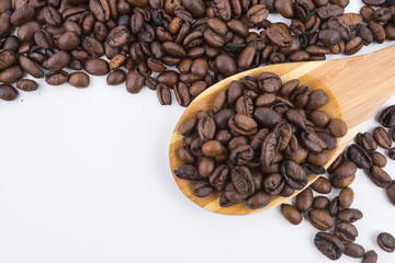 Concept roasted coffee beans in wooden ladle with isolated white background
