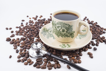 Concept roasted coffee beans, hot coffee and stethoscope isolated white background