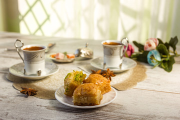 Two cups of Turkish coffee and a plate with baklava