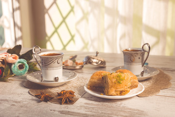 Two cups of Turkish coffee and plate with baklava