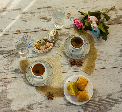 Two cups of Turkish coffee and a plate with baklava top view