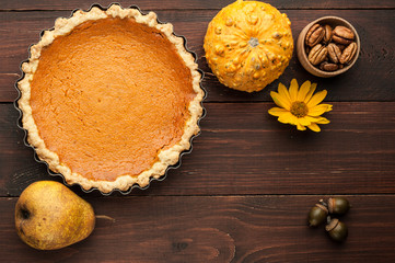 pumpkin homemade pie at wooden background arranged with food ingredients top view