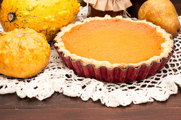 pumpkin homemade pie at wooden background arranged with food ingredients