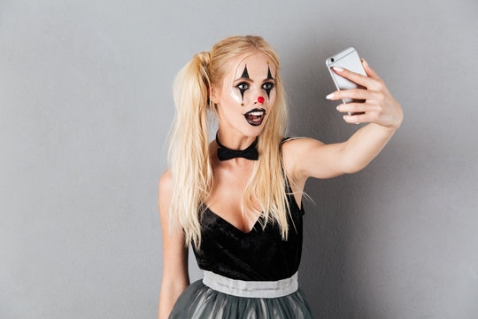Portrait of a beautiful blonde woman in halloween clown make-up