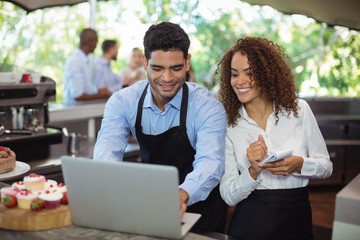 Fototapeta na wymiar Male waiter and female waitress with laptop