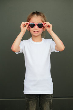 Girl kid wearing white blank  t-shirt with space for your logo or design in casual urban style