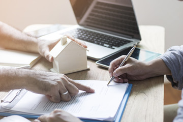 Home buyer are sign contract on sheet  with agent or broker in office, concept as agreement of...