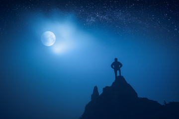 Fototapeta premium Silhouette of man standing on a cliffs edge