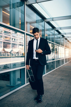 Handsome businessman using mobile phone at airport