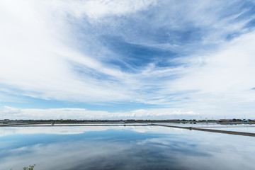 Blue sky and white clouds, water reflections in salt farming (Naklua),in the coastal, Phetchaburi provinces of Thailand, Landscape