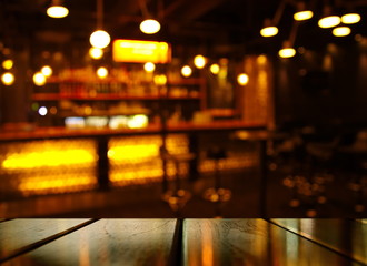 Fototapeta top of wood table with light reflection with abstract blur bar or club in the dark night background obraz
