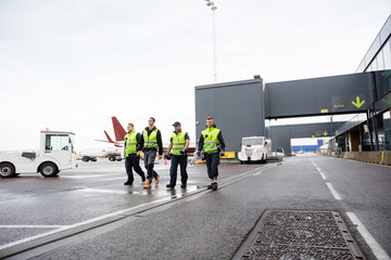 Naklejka premium Full Length Of Workers Walking Together On Runway