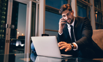 Businessman at airport waiting lounge using laptop and mobile ph