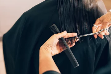 Crédence de cuisine en verre imprimé Salon de coiffure Hairdresser cutting client's hair in beauty salon.