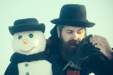 Gentlemen in black hats and scarves on blue sky