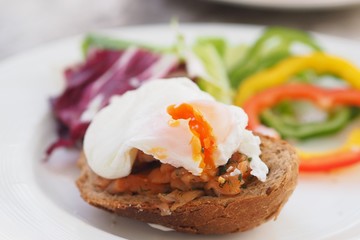 Healthy Breakfast with Wholemeal Bread Toast and Poached Egg with fresh Vegetables on dish.