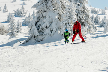 Fototapeta na wymiar Ski instructor and little boy on mountain
