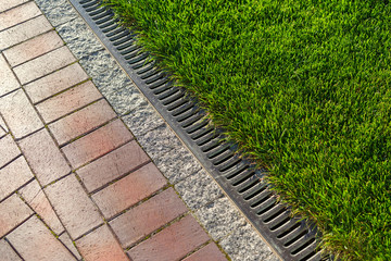 a metal drain on a stone path