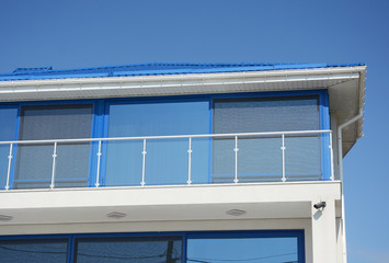 Close up on House Blinds Sun Protection with Glass Balcony. Windows in New Modern Passive House Attic with Shutters Closed and Opened Outdoors.