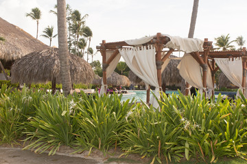 Tropical gazebo with chairs on amazing beach with palm tree