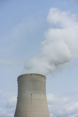 nuclear power plant chimney with condensation smoke on a cloudy day