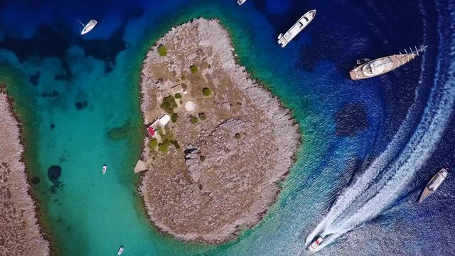 August 2017: Aerial drone video of small heart shaped island with picturesque church of Agia Marina and turquoise clear waters, Symi island, Dodecanese, Aegean, Greece