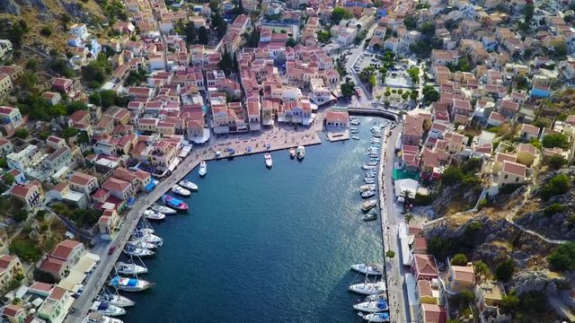 August 2017: Aerial drone video of picturesque port of Symi island with colourful neoclassic houses, Dodecanese, Aegean, Greece