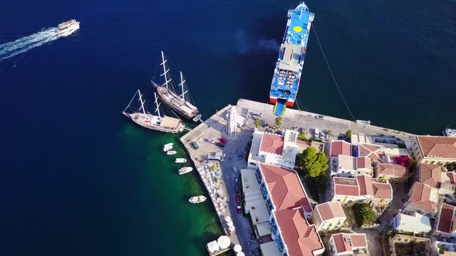 August 2017: Aerial drone video of picturesque island and main port of Symi with traditional architecture and dominant colors, Dodecanese, Aegean, Greece