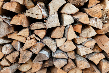 Firewood stacked in a woodpile on wooden background. Background of firewood stack.