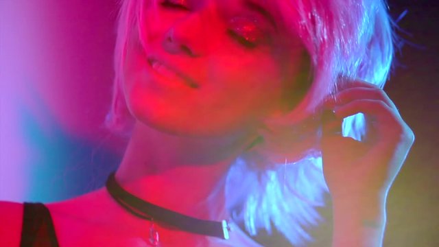 Disco girl dancing on party. Young model woman in colorful bright lights with trendy makeup and haircut. Slow motion 240 fps. 4K UHD video 3840x2160