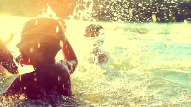 Little boys having fun in water outdoors, kids swimming together in river water. Summer holidays. Slow motion 240 fps. 4K UHD video 3840x2160