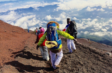 Guy with a travel backpack on the top of a boulder