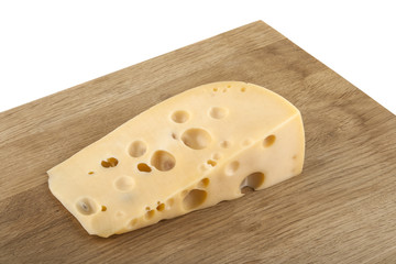 piece of cheese on a wooden table isolated on a white background