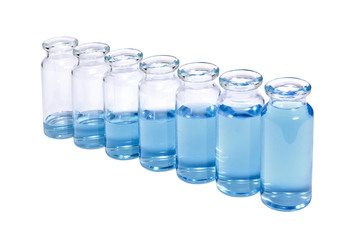 A row of phials with blue vaccine on white background