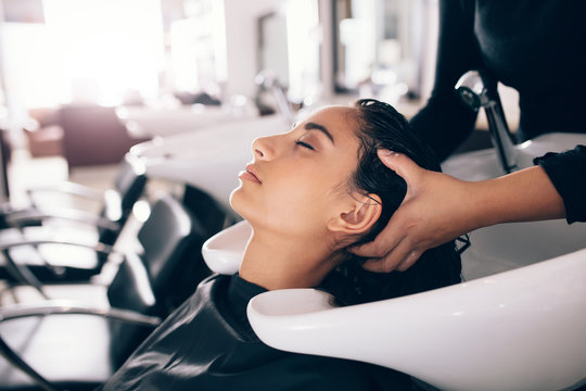 Hairdresser washing hair of customer at salon