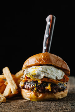 Breakfast burger with a fried egg on dark rustic surface
