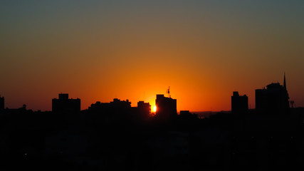 Silhouette of buildings against orange sunset in the city of Uruguaiana, Rio Grande do Sul, Brazil