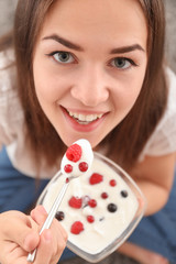 Young woman eating yogurt, closeup