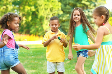 Fototapeta premium Cute little children blowing soap bubbles outdoors