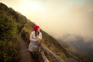 Young woman on a cliff overlooking the mountains