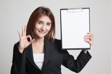 Young Asian business woman show OK and blank clipboard.