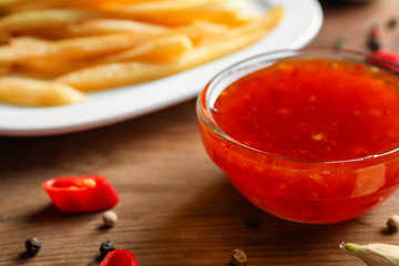 Glass bowl with chili sauce on kitchen table