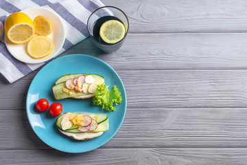 Plate of tasty sandwiches with fresh cucumber on wooden background