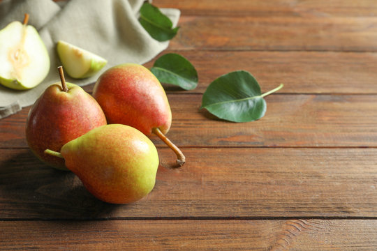 Delicious ripe pears on wooden background