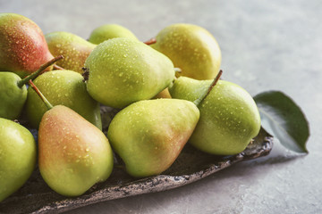 Plate with delicious ripe pears on table