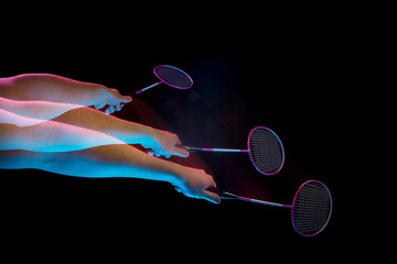 The hands of young man playing badminton over black background
