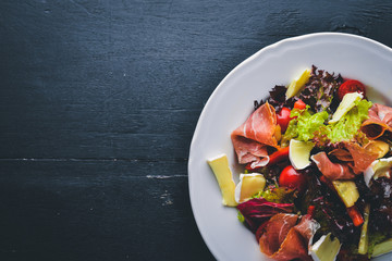 Vegetable salad and diced meat. On a wooden background. Top view. Free space.