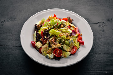 Salad of fresh vegetables and gorgonzola cheese. On a wooden background. Top view. Free space.