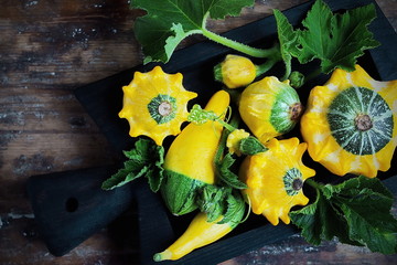 cute little decorative pumpkins in the black tray on old wooden table