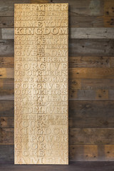 Wooden carved word of the Lord's Prayer on the  shabby wooden  p